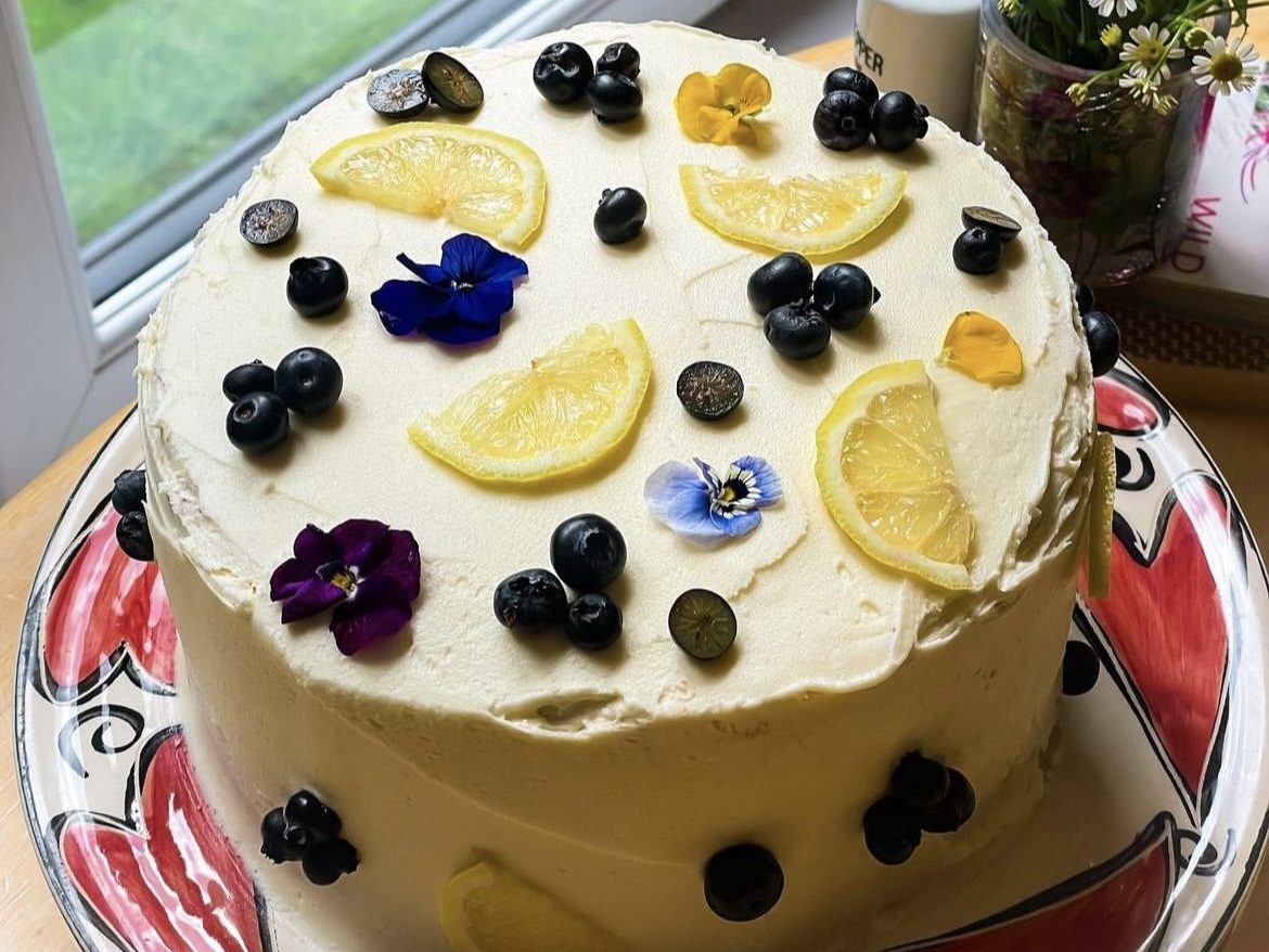 Vegan lemon and blueberry cake with vegan buttercream lemons and blueberries with edible flower