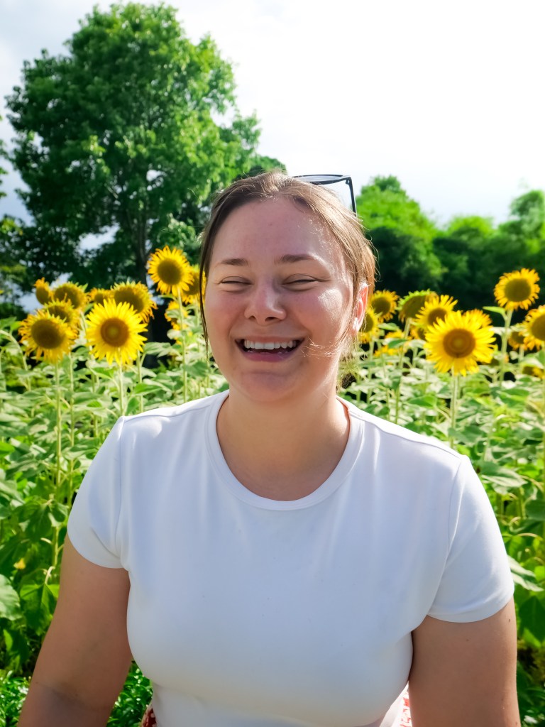 Woman laughing in a field of sunflowers in Hue Vietnam whilst travelling